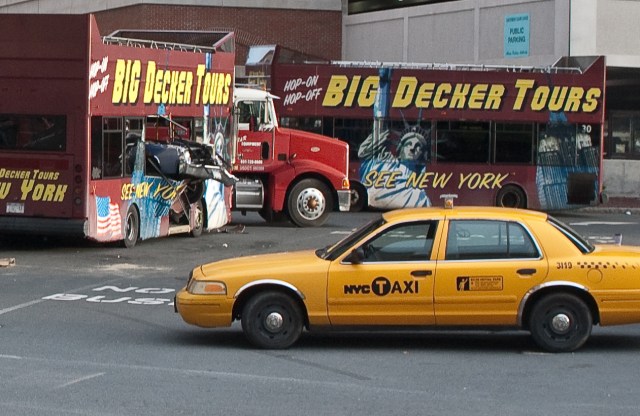 Various prop vehicles, including a tour bus that has been speared by a Chevy Malibu